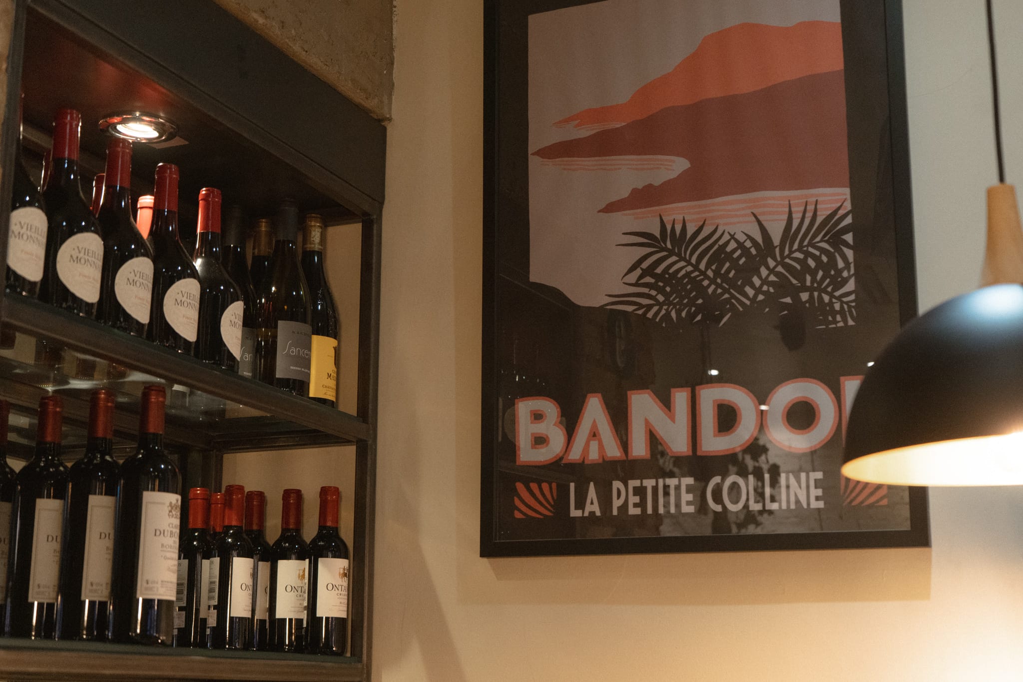 Wine shelves and French posters at La Petite Colline